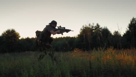 Un-Hombre-Armado-Corriendo-En-El-Ataque-Sosteniendo-En-Las-Manos-El-Arma-En-La-Atardecer