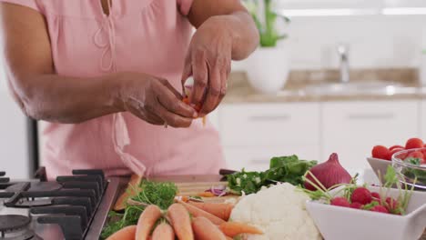 Happy-senior-african-american-woman-cooking-in-kitchen