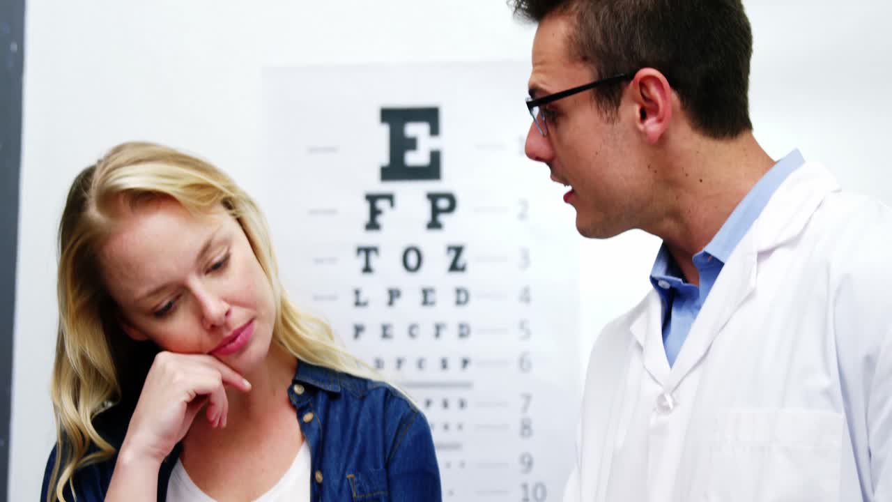 optometrista discutiendo el informe de la prueba ocular de una paciente femenina
