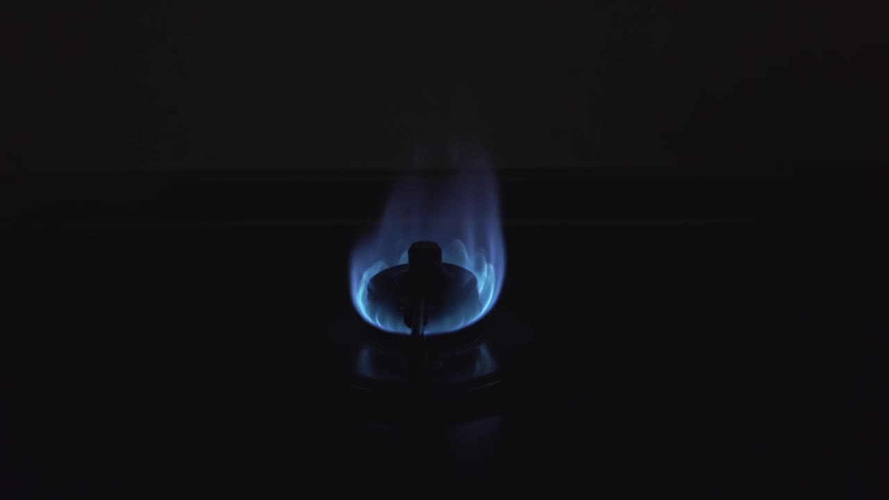 Lighted gas stove in the kitchen.