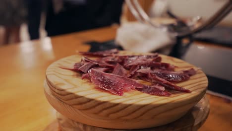 slicer serves a plate of spanish serrano ham