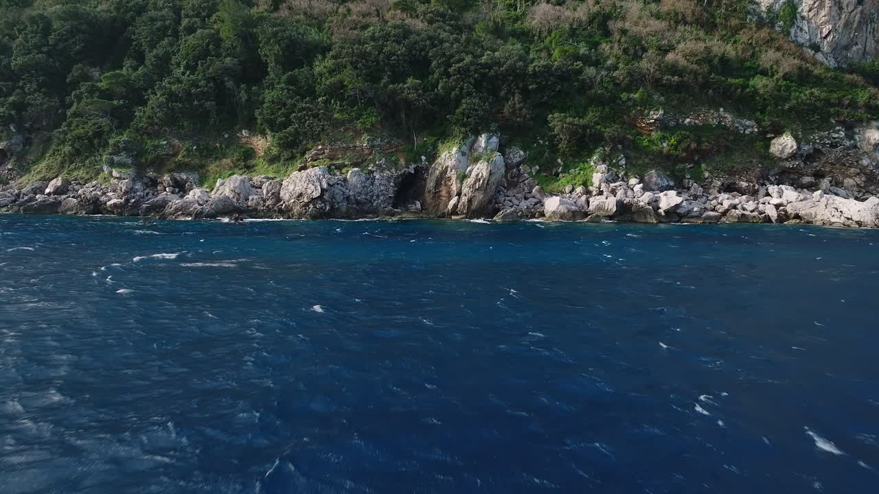 costa rocosa con una cueva cerca de capri, italia con exuberante vegetación y mar azul profundo, vista aérea