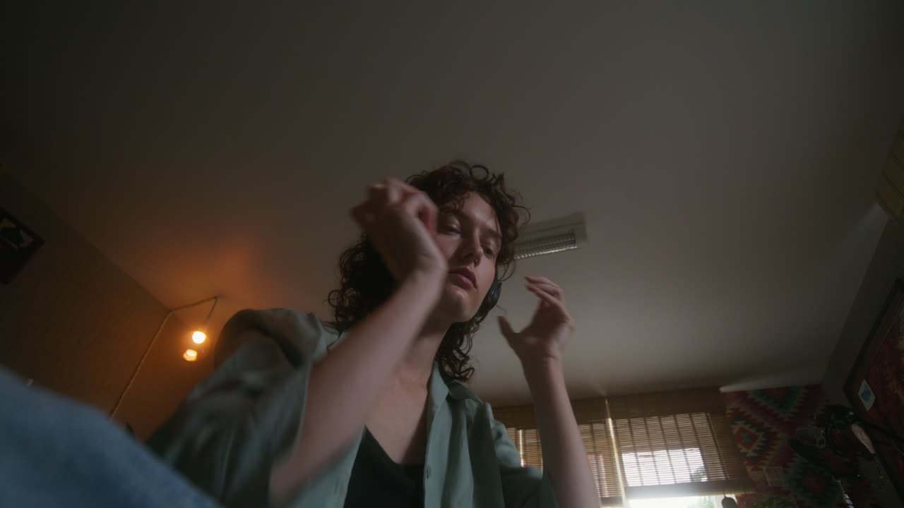 mujer usando teléfono y auriculares en casa