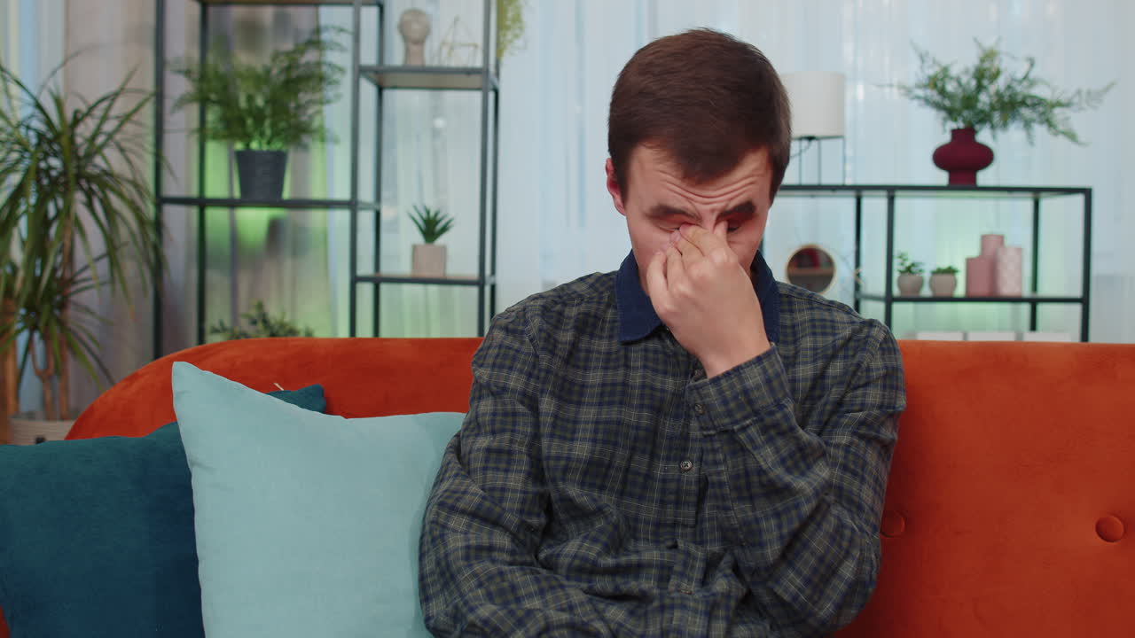 집에 있는 젊은 남자가 불공평한 상황으로 고통받고 있습니다. 문제, 헤어짐, 우울증, 기분이 나 ⁇ 고, 번아웃