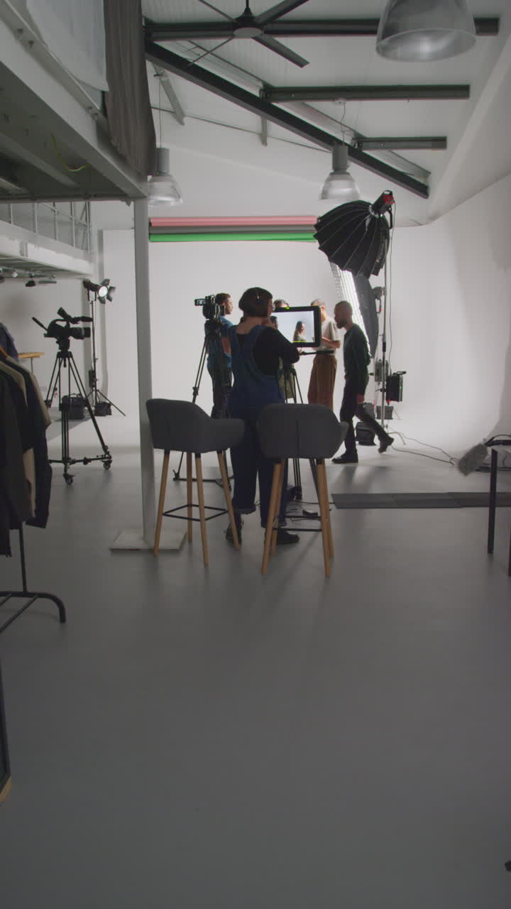 vídeo vertical de actores que trabajan en el set rodando una película o vídeo en estudio con el director, el camarógrafo, el grabador de sonido y el asistente