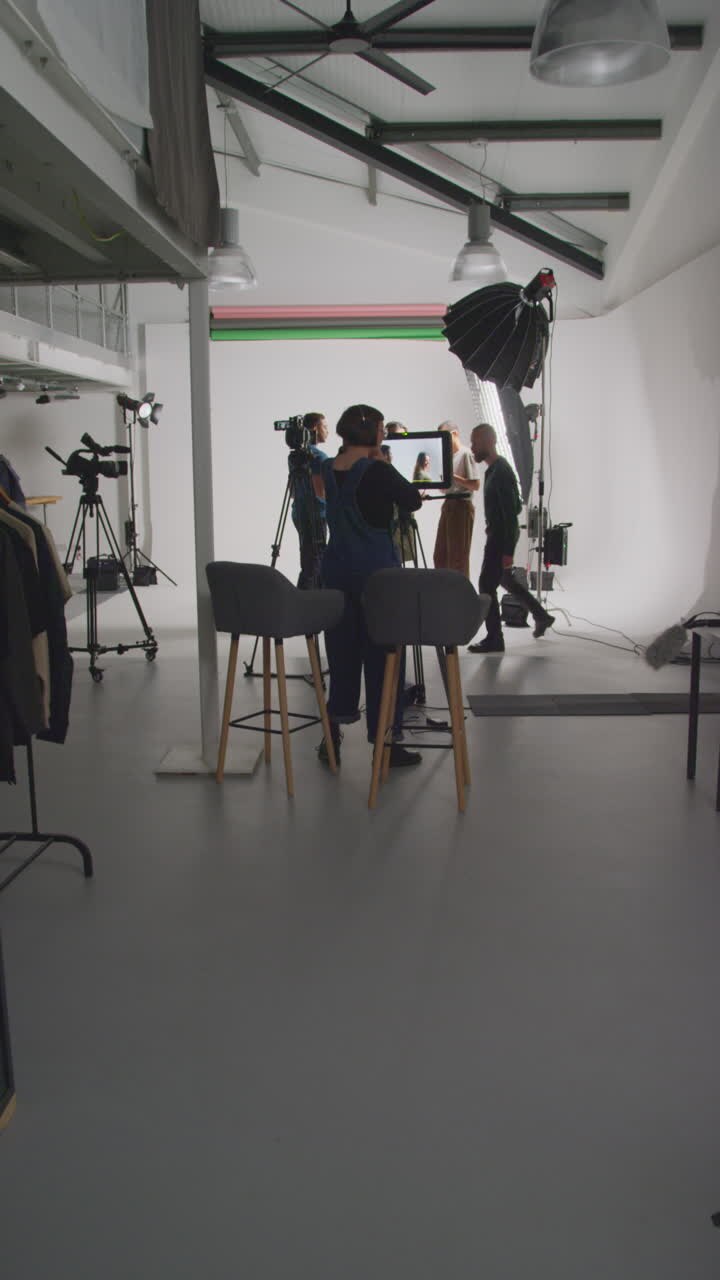 Vertical Video Of Actors Working On Set Shooting Movie Or Video In Studio With Director Film Cameraman Sound Recordist And Assistant
