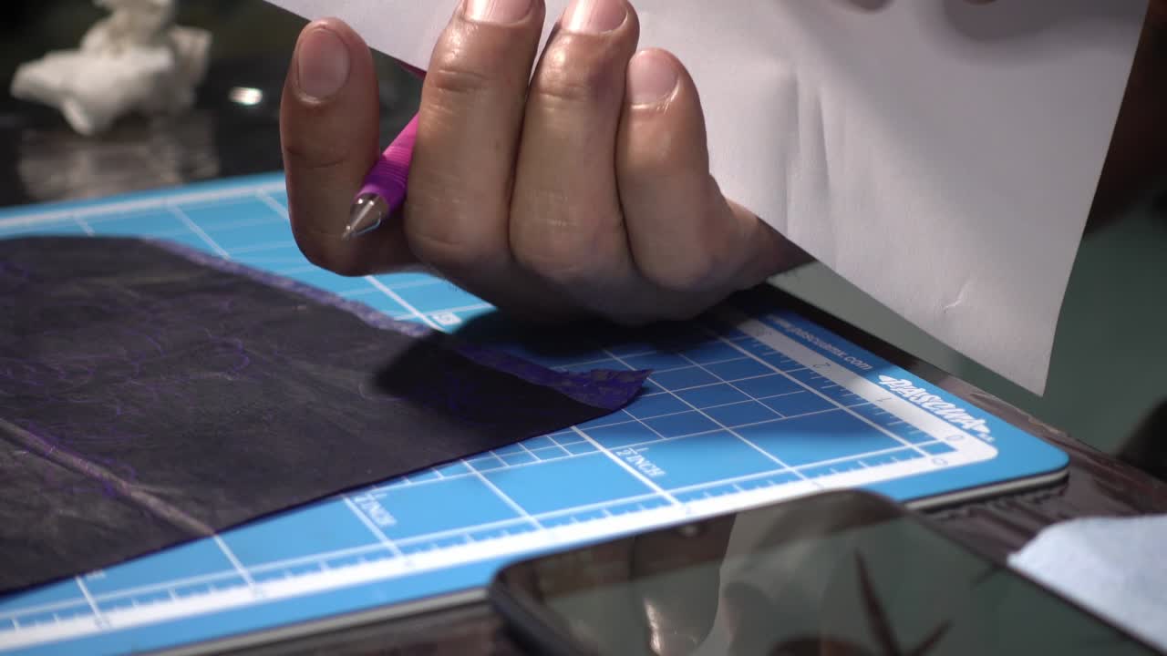 un artista del tatuaje dibujando un tatuaje en una hoja blanca