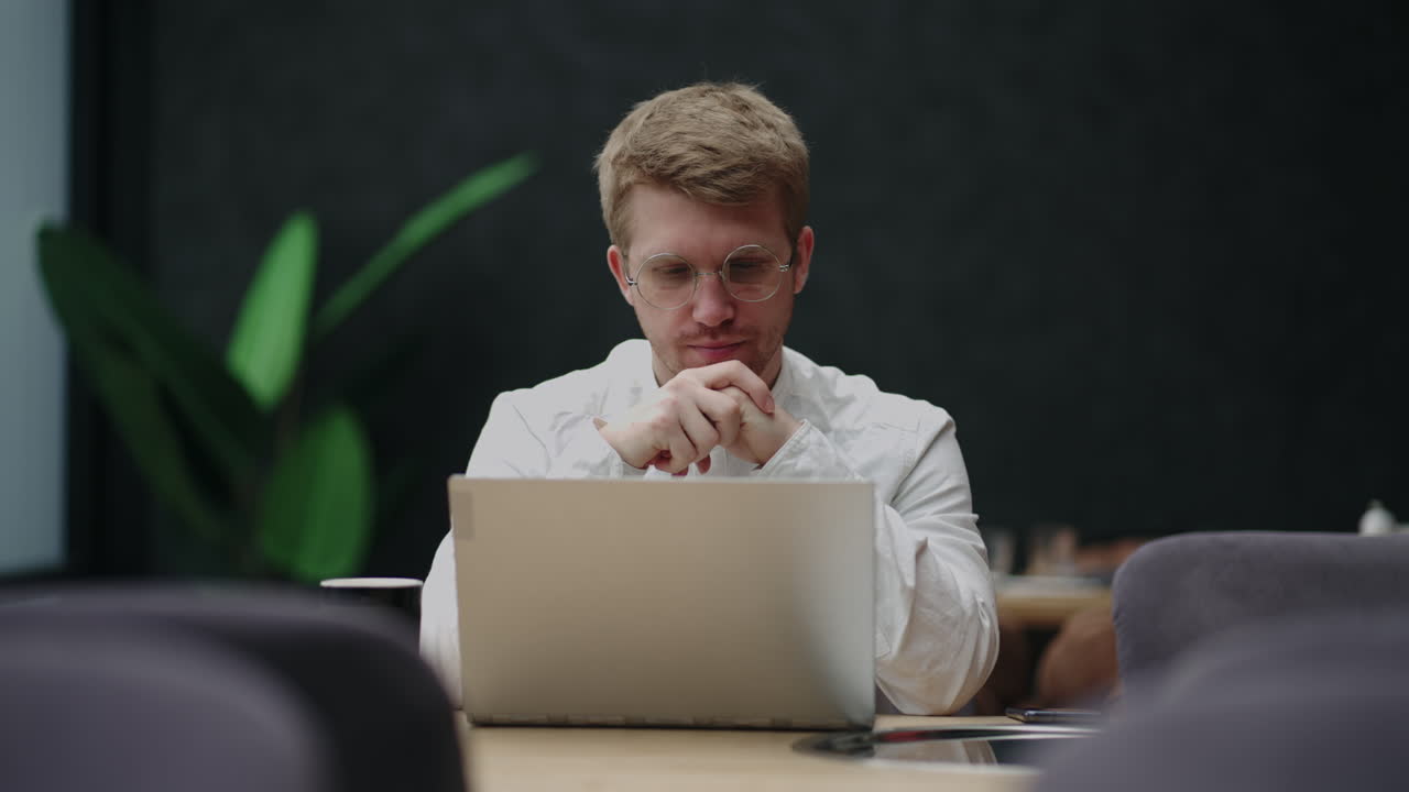 businessman is reading news in internet by laptop in his modern office thinking and planning strategy