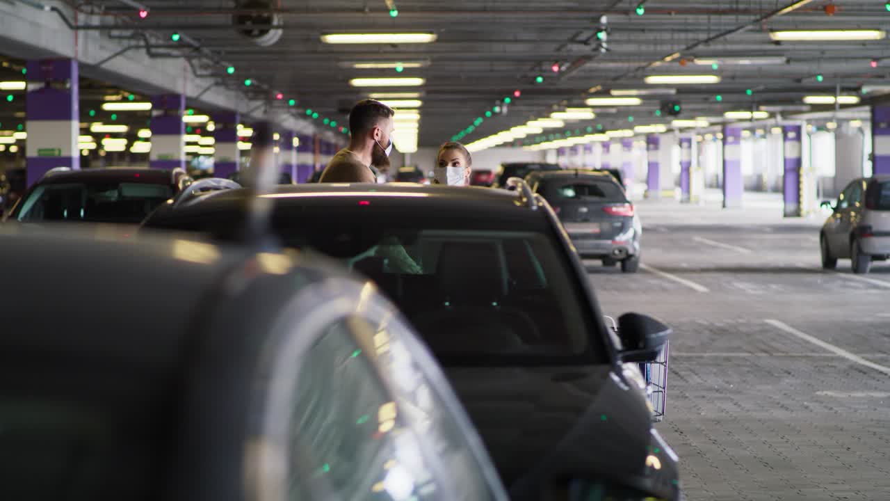 vista lateral de la pareja con la máscara volviendo de las compras