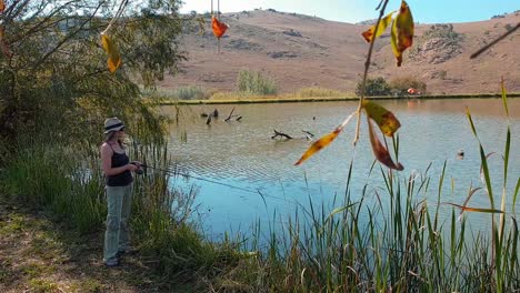 girl fishing from shore at beautiful lake in the mountains