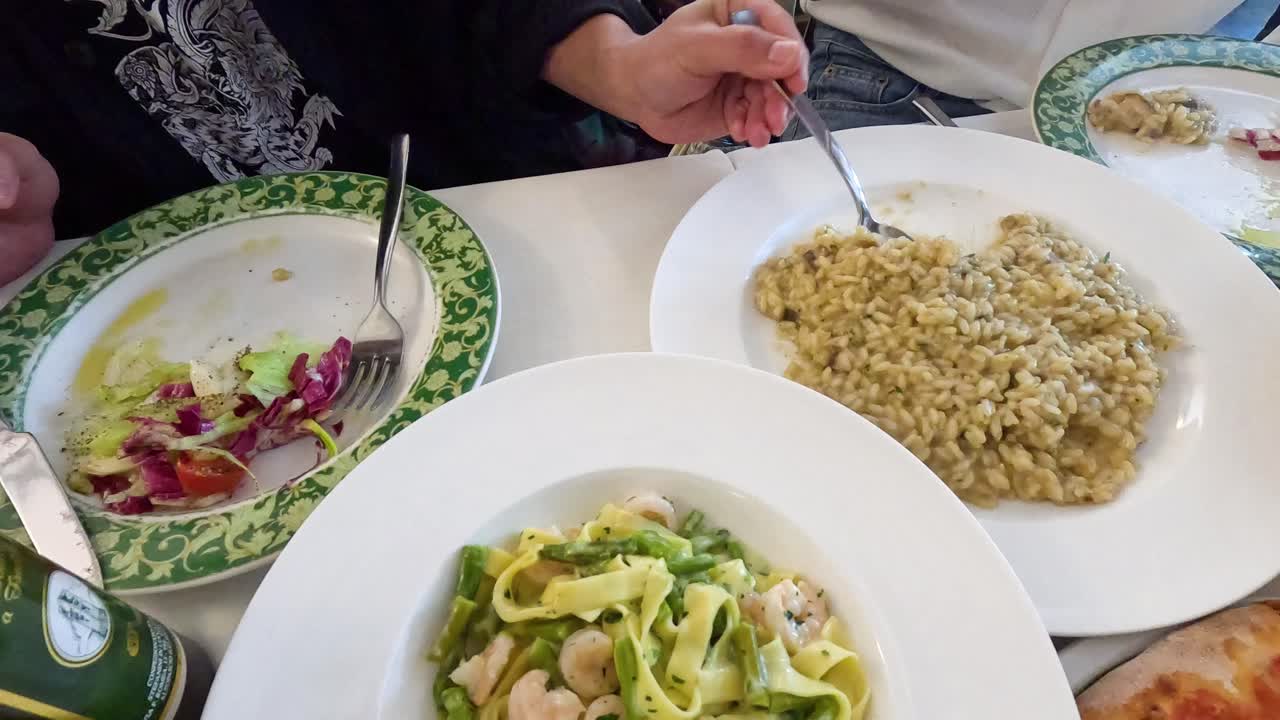 dos personas disfrutando de platos de risotto y pasta