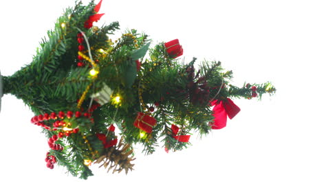 Christmas-decorated-small-tree-with-red-and-gold-decorations-slowly-lights-up-a-light-chain-wrapped-around-a-tree-of-yellow-color-lights-in-slow-motion-capture