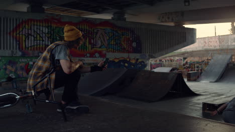 stylish man recording video on mobile phone with roller skater training.