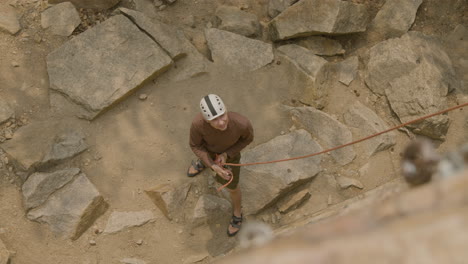 un grimpeur au fond de la falaise