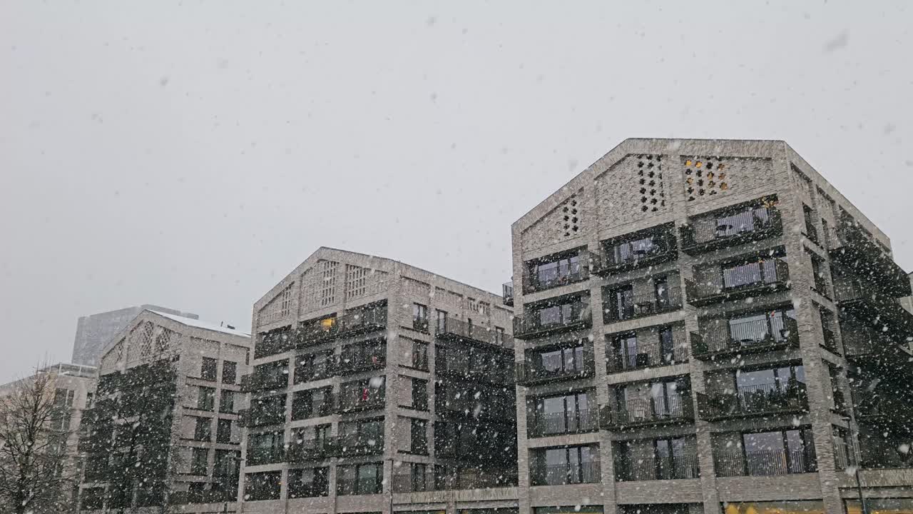 Modern residential buildings in Eilandje, Antwerp, during heavy snowfall, highlighting luxury design, large windows and urban winter ambiance