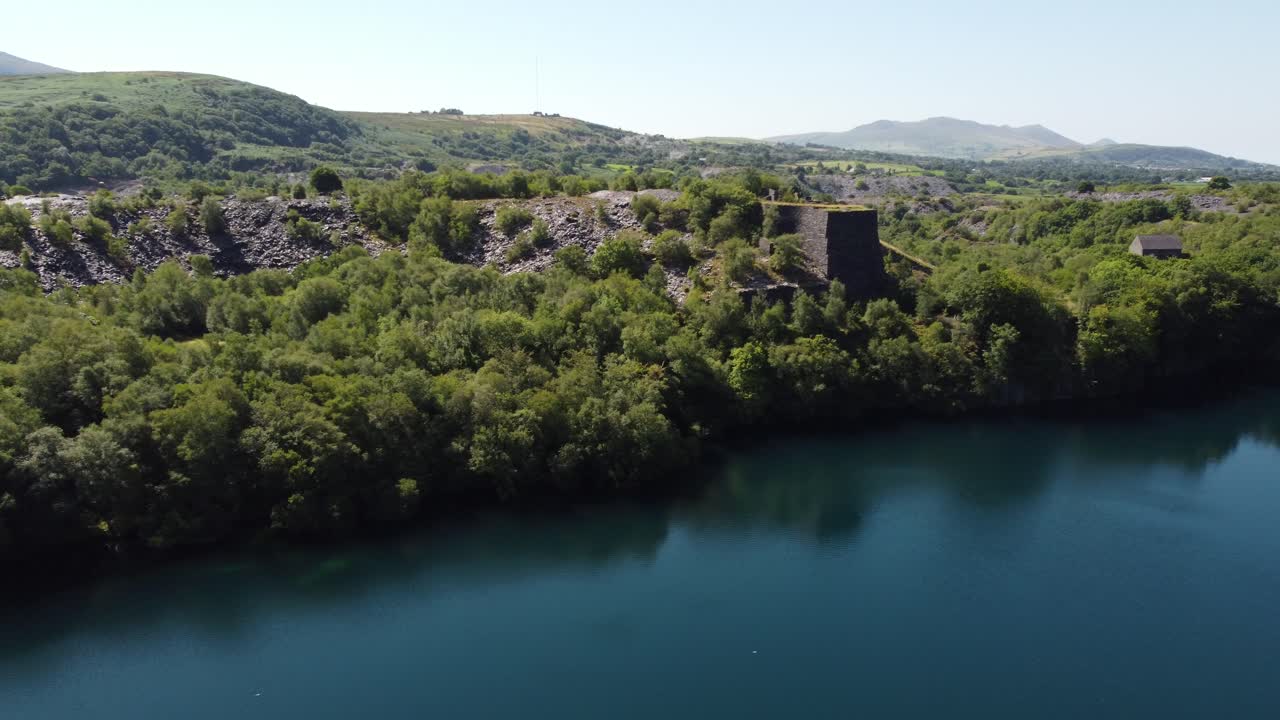 vista aérea del valle del bosque galés eje minero de pizarra y lago de cantera bajo las montañas de snowdonia