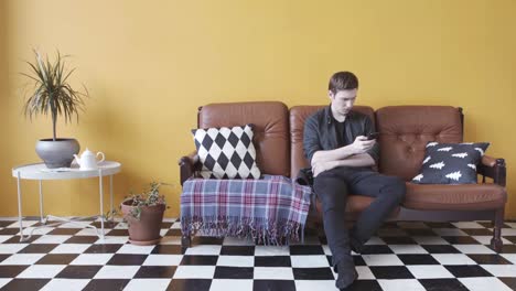 man using phone on a couch