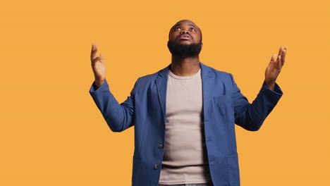 man looking up to sky hoping for miracle, studio background