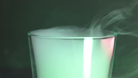 humo verde que fluye de un vaso