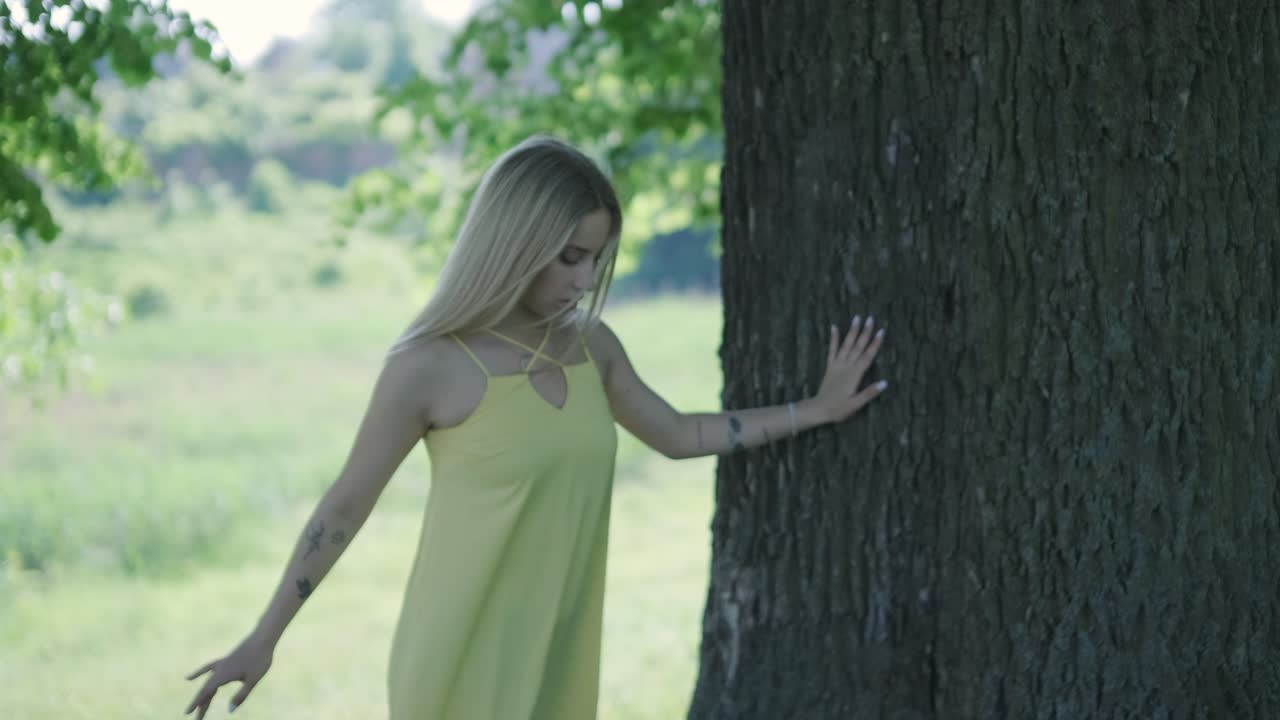 여름 공원에서 나무 에서 춤을 추는 노란색 드레스를 입은 여자