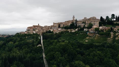 Drone-shot-of-Montepulciano-in-Tuscany,-Italy-surrounded-by-greenery