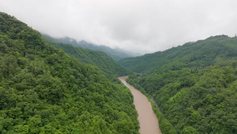 drone flying along a flooding river in middle of jungle. monsoon season in china