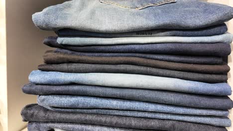 stack of folded denim jeans in various shades