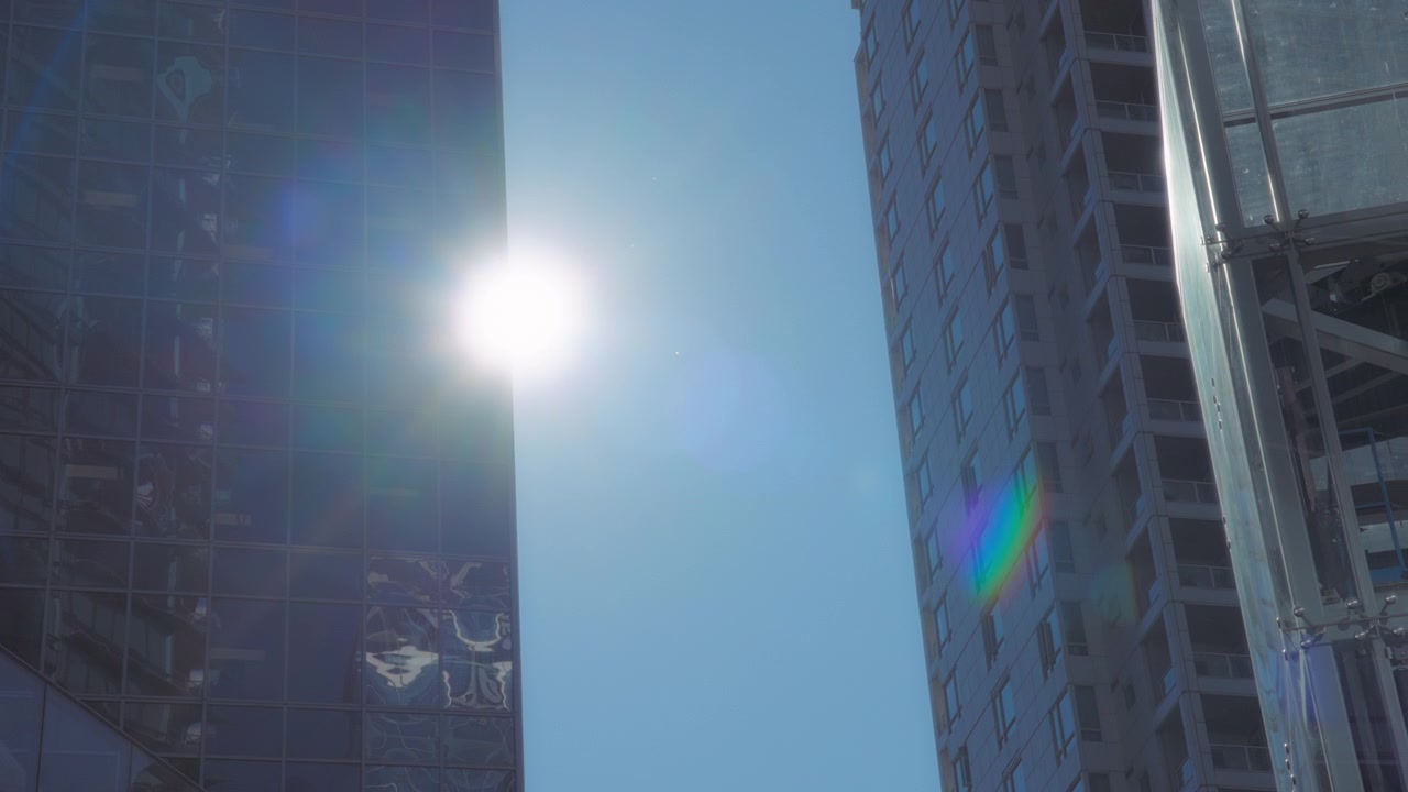 Die Sonne scheint hinter dem hohen Gebäude hervor