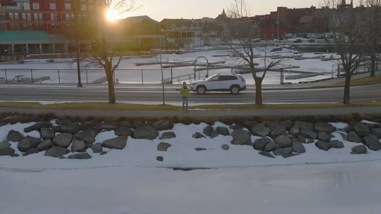 카메라를 보고 눈 공중 없이 늦은 겨울 저녁을 즐기는 젊은 여성