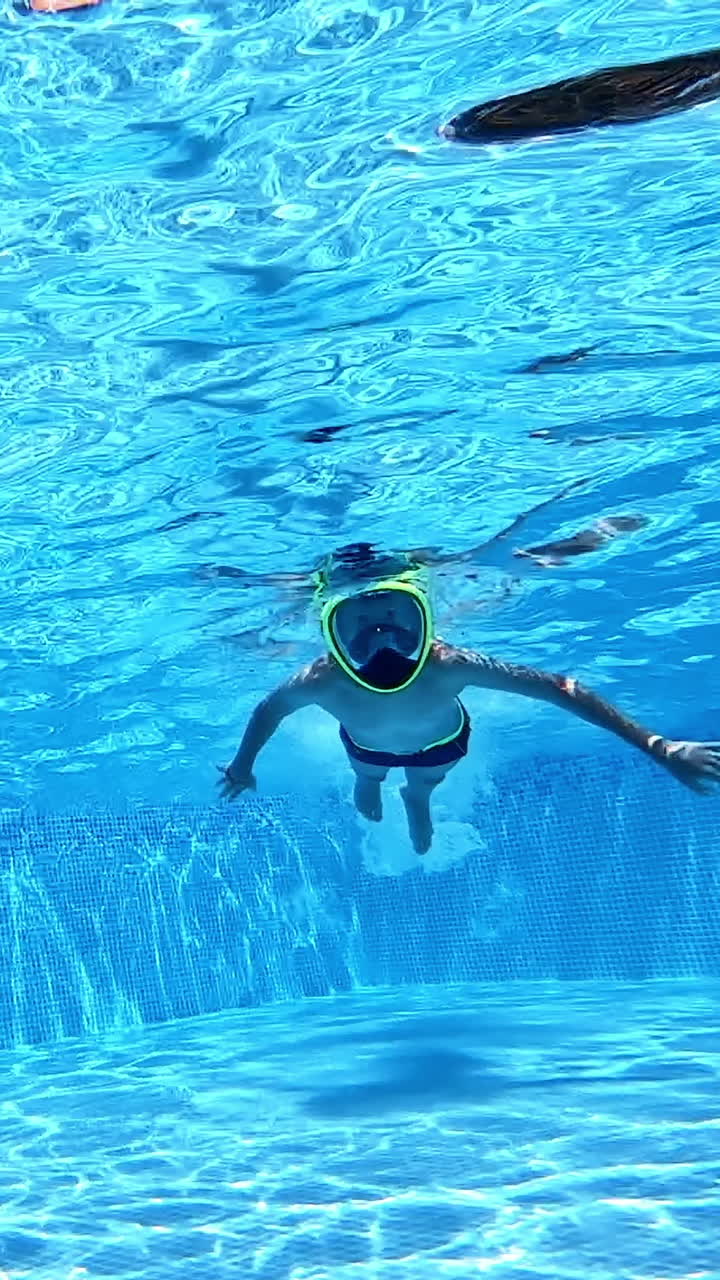 Happy boy underwater. Boy swimming with underwater mask in pool