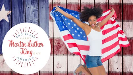 Animation-of-happy-martin-luther-king-day-text-over-happy-african-american-woman-with-american-flag