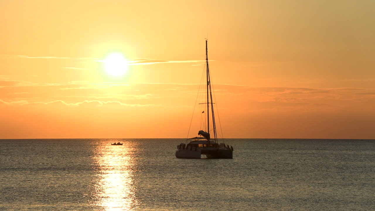 transición borrosa a un barco en cala codolar en la hora dorada del atardecer, ibiza, españa