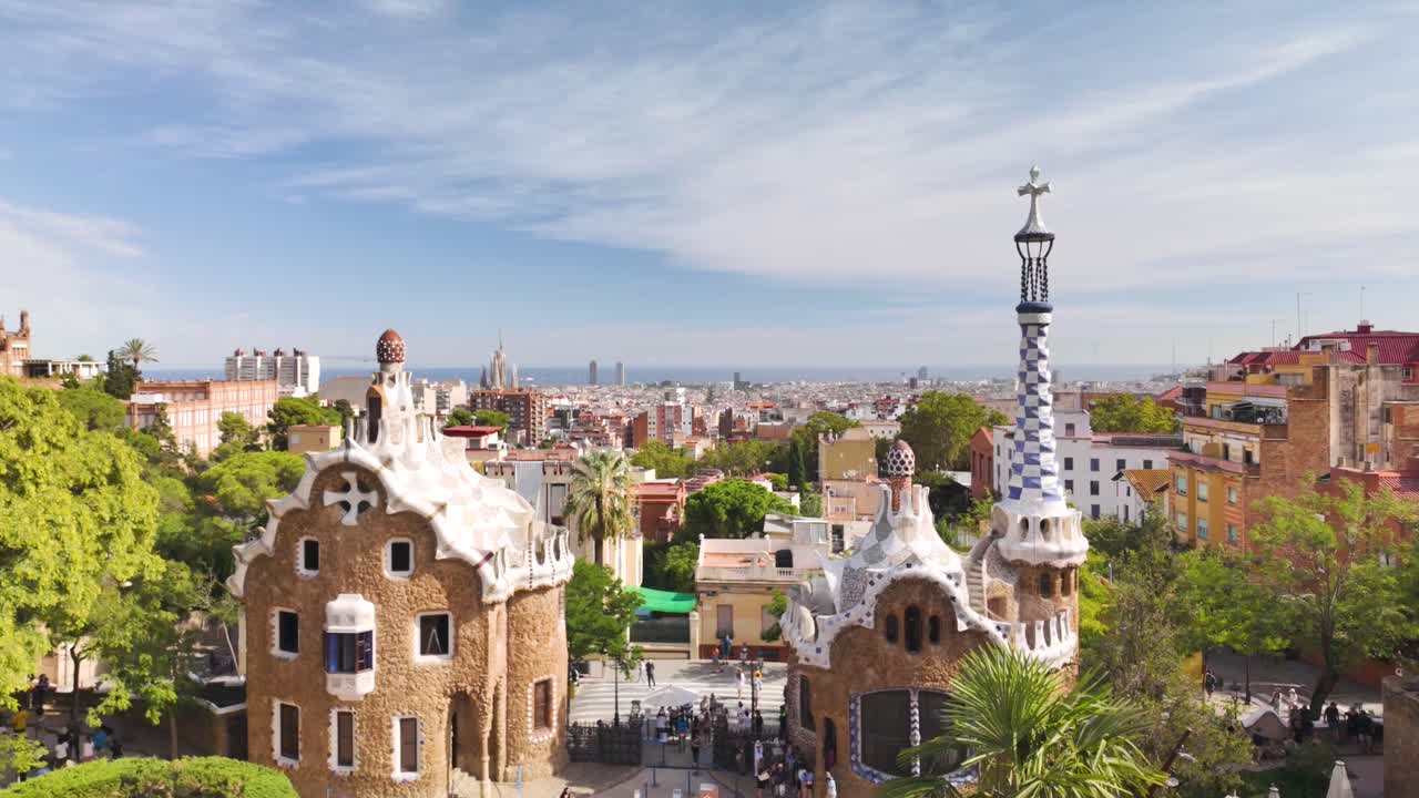 Iconic Park Güell architecture with vibrant ceramic mosaic tiles overlooking Barcelona on a sunny day. Pull Back Shot