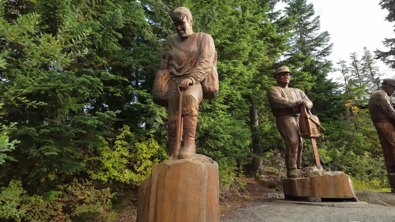 Gimbal wide panning shot of historical wood carvings on Grouse Mountain during the fall season in North Vancouver, British Columbia, Canada. 4K