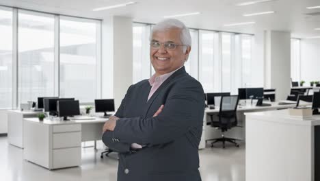 Portrait-of-Happy-Indian-senior-businessman-standing-crossed-hands