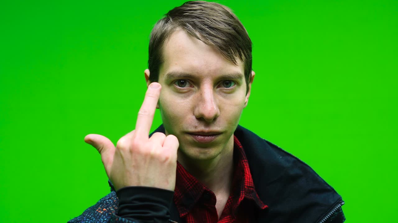 Young man in casual clothing showing middle finger, rude sign of disrespect, making a fuck gesture