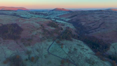 Autumn-landscape-with-sunrise-kissed-hills-and-mountains-in-the-background