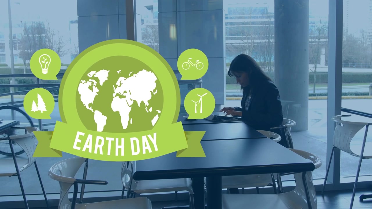 Donna d'affari che lavora al laptop in ufficio con grafica del Giorno della Terra in sovrapposizione