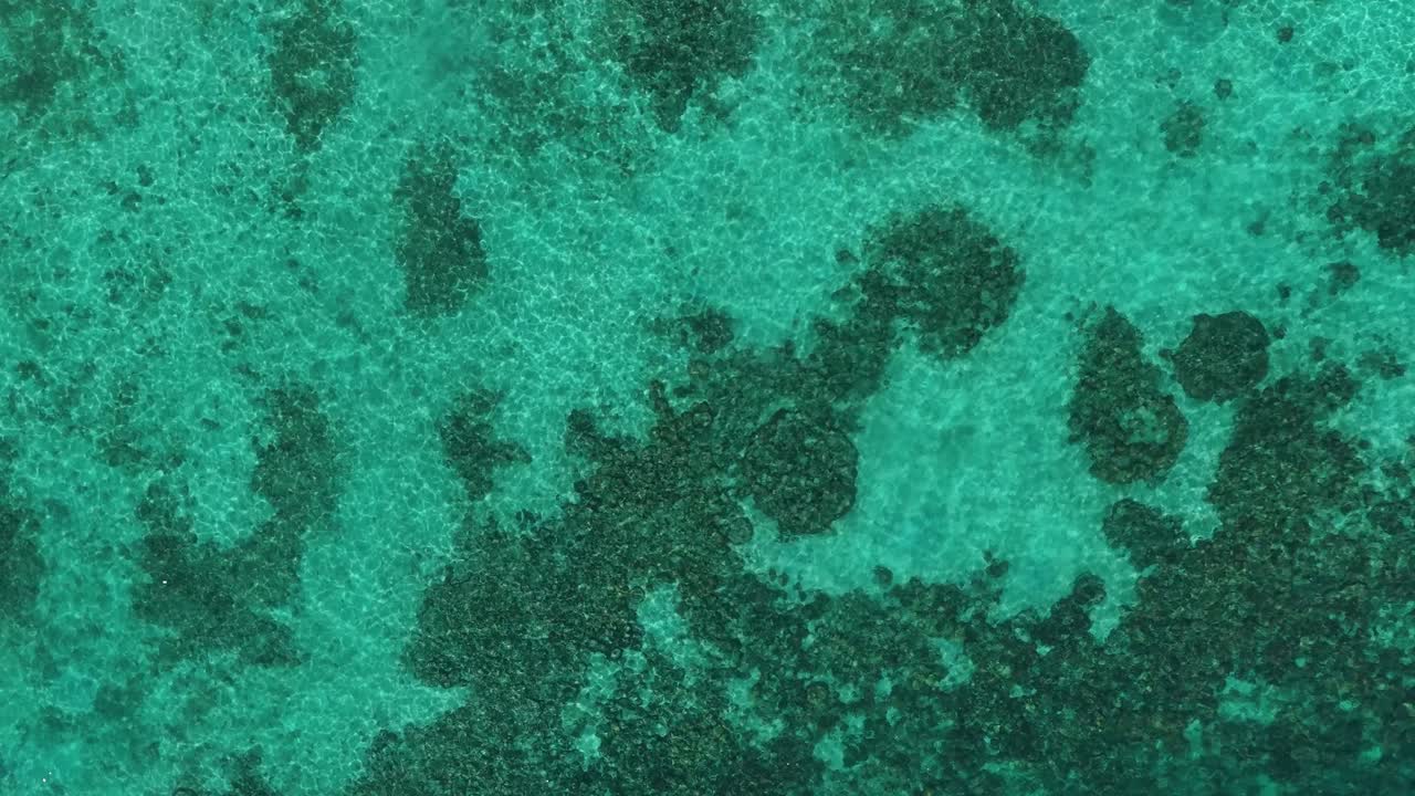 Vista aérea de agua de océano turquesa cristalina y arrecife de coral