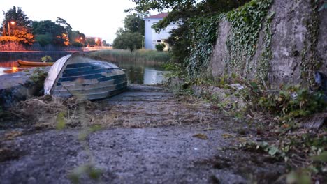 Altes-Umgedrehtes-Kanu,-Das-Neben-Wasser-Sitzt