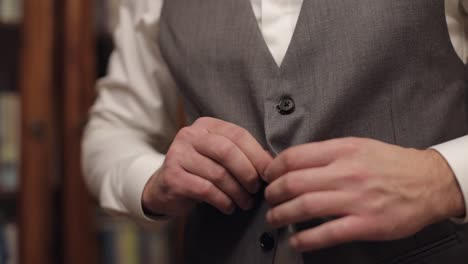 buttoning jacket with hands close up, man in suit fastens buttons on his jacket preparing to go out