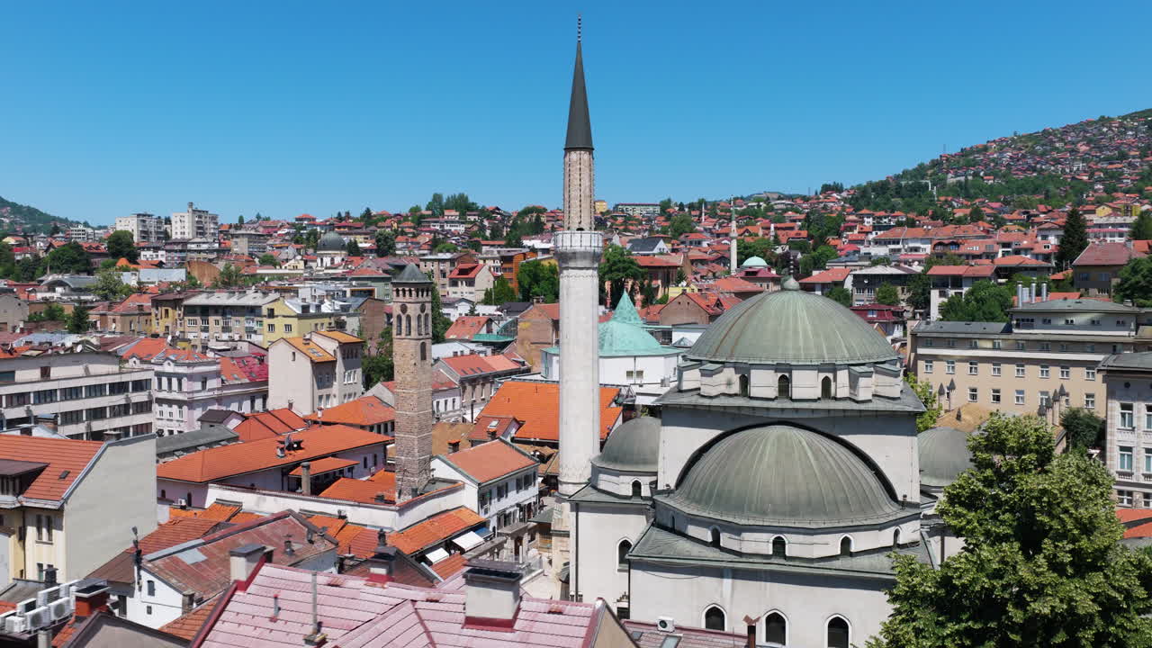 Minaret And Domed Roof Of Gazi Husrev-beg Mosque On Sunny Day In Sarajevo, Bosnia and Herzegovina. wide drone shot