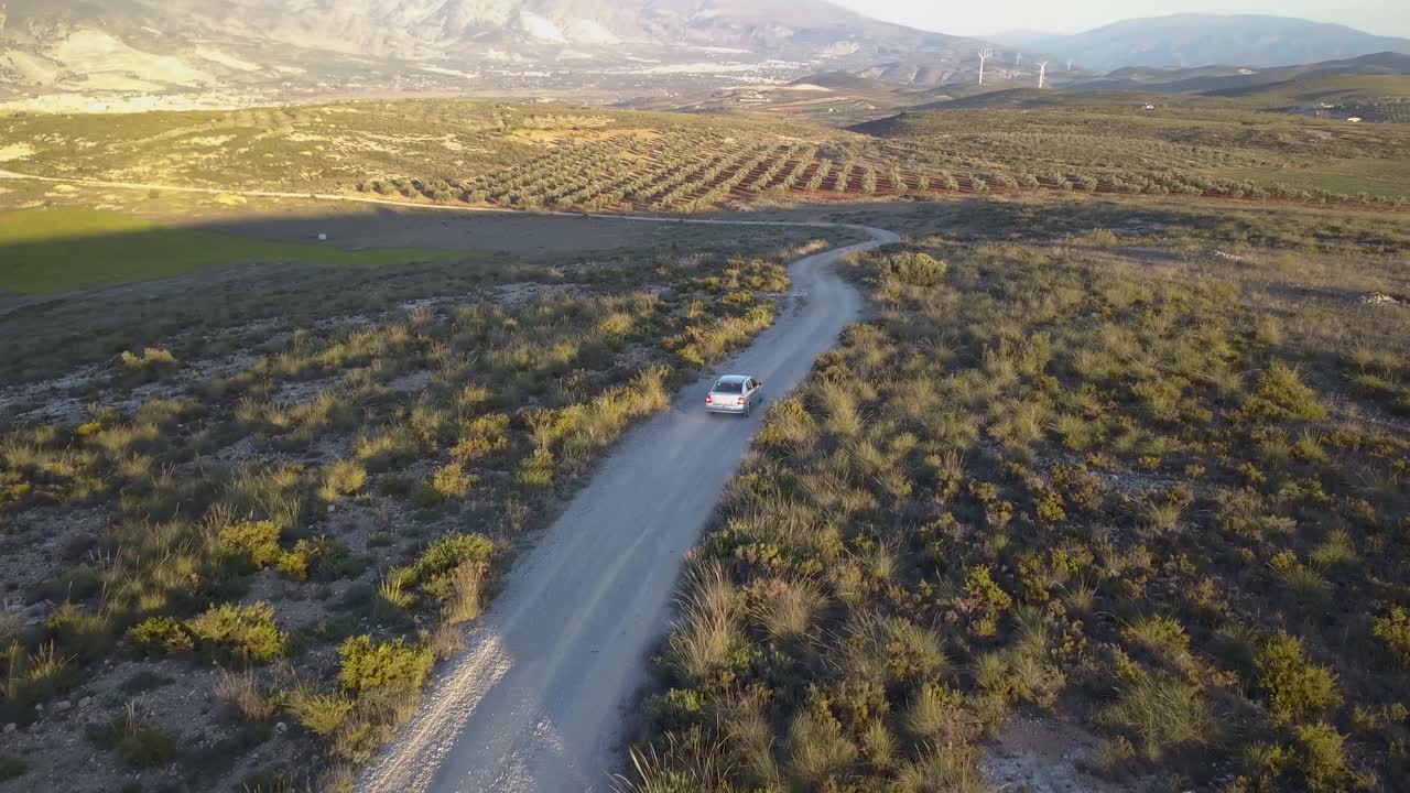 vista de seguimiento aéreo de un coche conduciendo fuera de la carretera en el campo