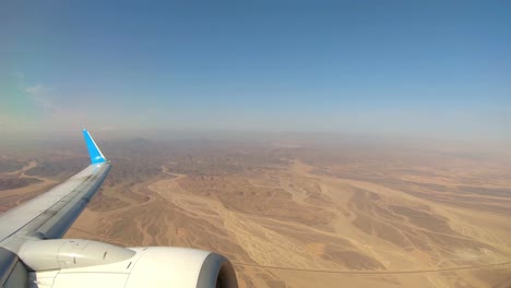 plane flying over desert after departing from marsa alam airport, egypt