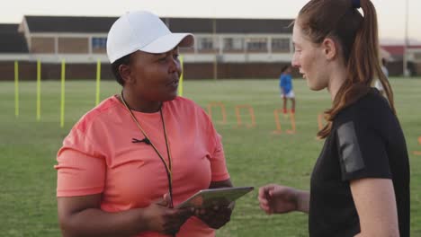 young adult female rugby player and coach at training