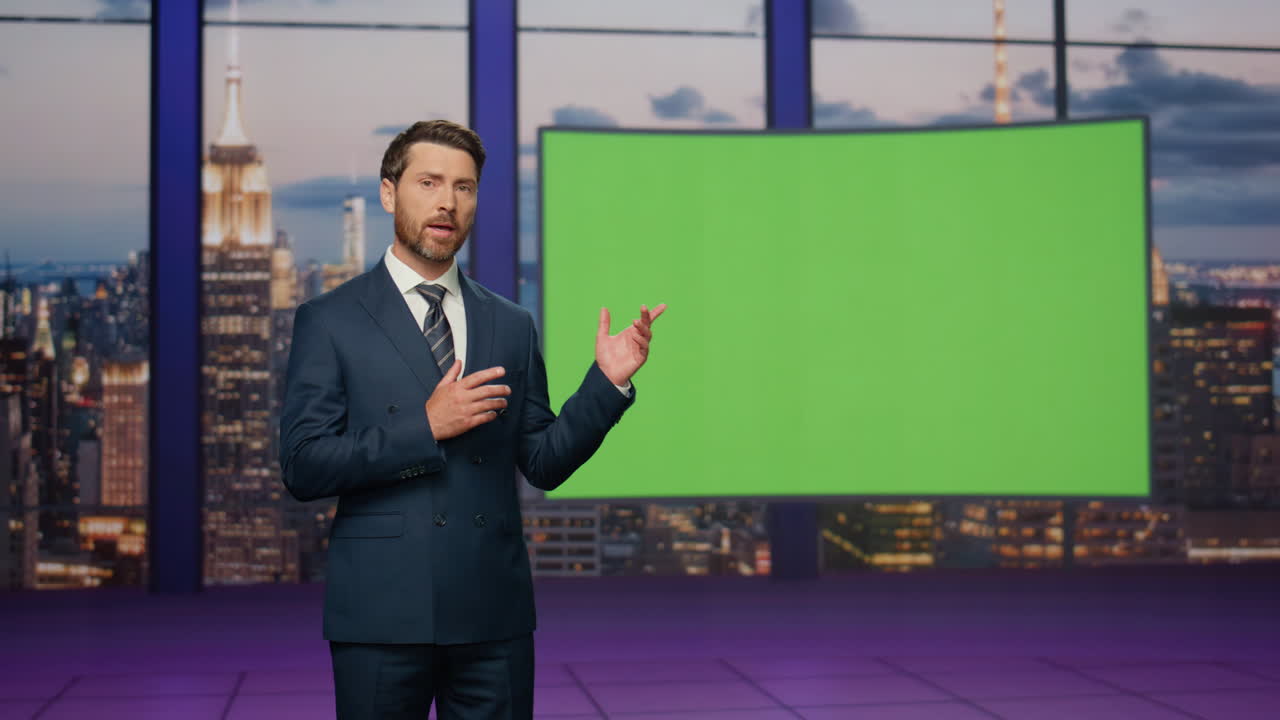 el presentador muestra una pantalla verde reportando noticias de última hora en el estudio del canal de televisión.
