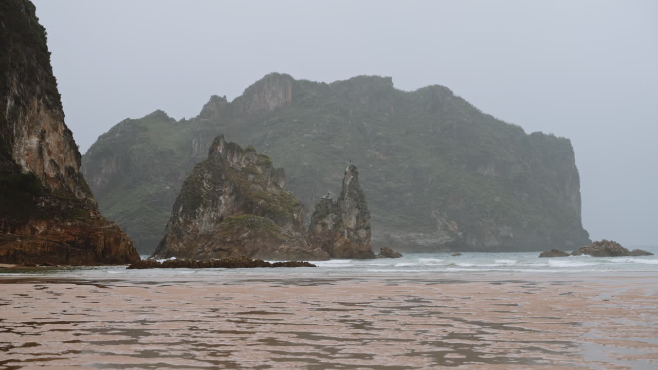 Misty Coastal Landscape with Rocky Outcrops and Beach