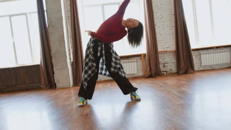 young woman dancing and stretching in a bright studio