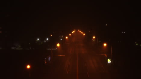 camino espeluznante y luces de la calle en la noche con un camino vacío