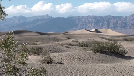 Personas-Distantes-Explorando-El-Terreno-De-Dunas-De-Arena-En-El-Valle-De-La-Muerte,-Desierto-De-Mojave,-California,-Tiro-De-Revelación-De-La-Derecha-De-La-Plataforma-Aérea